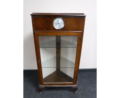 A mid 20th century walnut corner display cabinet fitted with a Smiths clock 