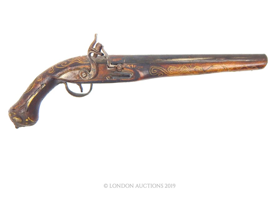 An 18th Century South East Asian Flintlock Pistol With Brass Inlay. A 