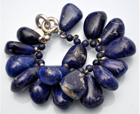 Hoorieh Coish: a lapis lazuli bangle, in baroque form beads with silver clasp, 17cms long.
