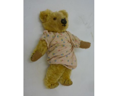 A Chad Valley teddy bear, c.1935, with black/amber eyes, button to ear, worn gold plush, replaced pads, 14" high (Est. plus 1