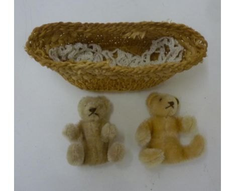 A pair of Steiff miniature teddy bears in beige plush, one with button in ear, 3 1/2" high, dated 1980's, in Moses basket (3)