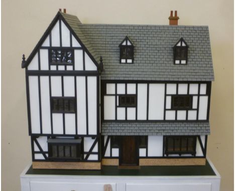 A cabinet made dolls house, painted wood construction, three storey Tudor half timbered style with dormers to roof, opening f