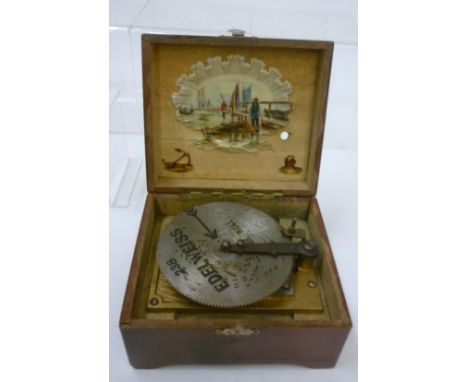 An Edelweiss disc player musical box with hand cranked movement in stained wood box with coloured print to lid, playing 4 1/2