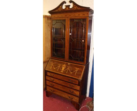A circa 1900 Sheraton Revival mahogany, floral satinwood inlaid and further cross banded bureau bookcase, having broken archi