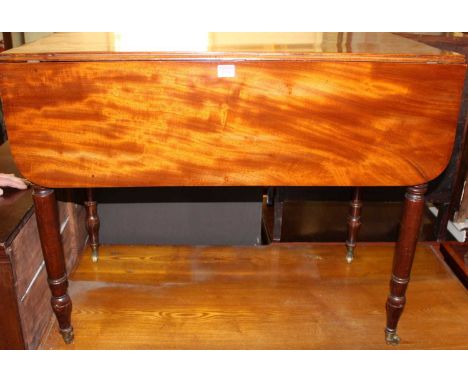 An early 19th century mahogany Pembroke table, having rounded fall leaves, single end drawer and raised on ring turned suppor