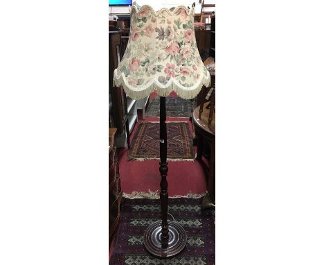 A contemporary mahogany turned standard lamp with shade