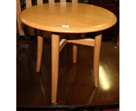 A contemporary Ercol light elm circular low occasional table, with inset label to underside, dia. 60cm