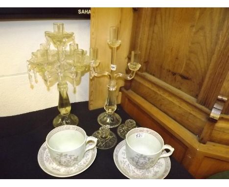 Two glass candelabra, two of glass candle sticks and a pair of Adams cup and saucers model number 2744 decorated in a floral 