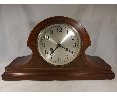 An Edwardian Napoleon hat-styled mahogany-cased mantel clock with inlaid panels and stringing to the case, silvered dial with