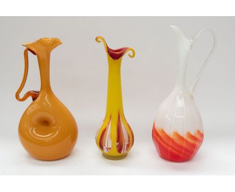 Three Vintage decorative art glass jugs/vases, to include; a tall white and orange swirl handled jug, a yellow glass handled 