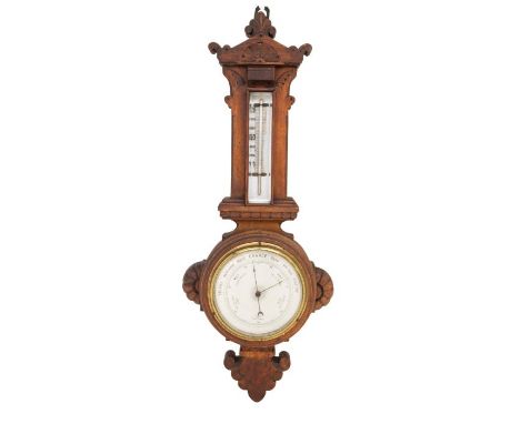 An oak cased aneroid thermometer and barometer, the wood being of a stylised design, no maker's mark, approx. 58cm long.