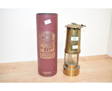 An early 20th century Cumbrian miner's oil lamp with presentation case, impressed number 287431 and maker mark, h26cm  Condit