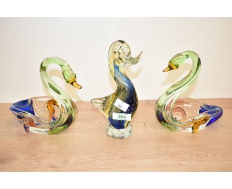 A large studio glass paperweight in the form of a duck, h19cm, sold together with a pair of studio glass swans, h16cm