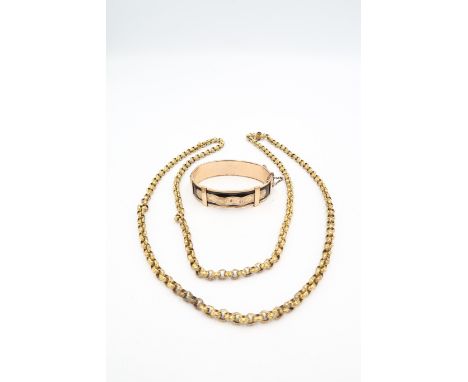 A rose coloured rolled gold bangle the black ground with rose gold belt detail, internal diameter 43.2 by 58.4mm, and a gold 