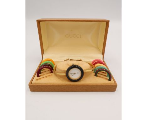 A vintage Gucci watch of bangle form with interchangable bezels in ten colours including the iconic Gucci green and red strip