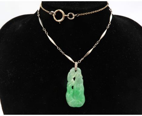 A carved jade pendant with rose cut diamond bail to the torpedo link panel neck chain. Tests platinum and 18ct. Weight 12.80 