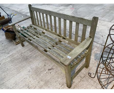 A WOODEN SLATTED THREE SEATER GARDEN BENCH