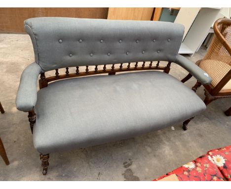 A LATE VICTORIAN LOVE COUCH WITH TURNED AND FLUTED FRONT LEGS,TURNED SPINDLE AND BUTTON BACK