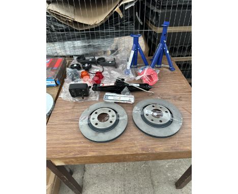 AN ASSORTMENT OF NEW CAR SPARES AND TOOLS TO INCLUDE AXEL STANDS, BRAKE DISCS AND LIGHTS ETC