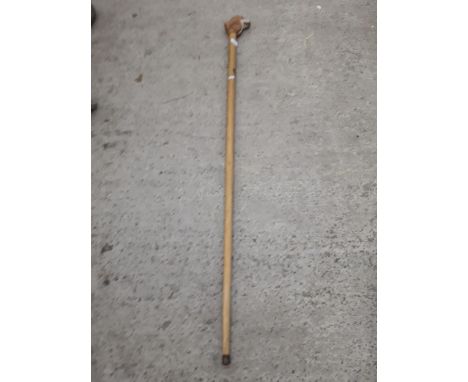 A TALL WOODEN WALKING STICK WITH CARVED DOGS HEAD HANDLE