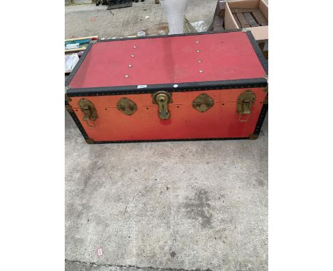 A RED COMPRERSSED FIBRE TRAVEL TRUNK