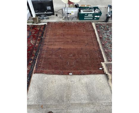 A VINTAGE RED PATTERNED FRINGED RUG