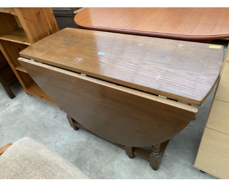 AN OVAL OAK OLD CHARM GATE LEG DINING TABLE ON TURNED LEGS, 59.5" X 45" OPENED