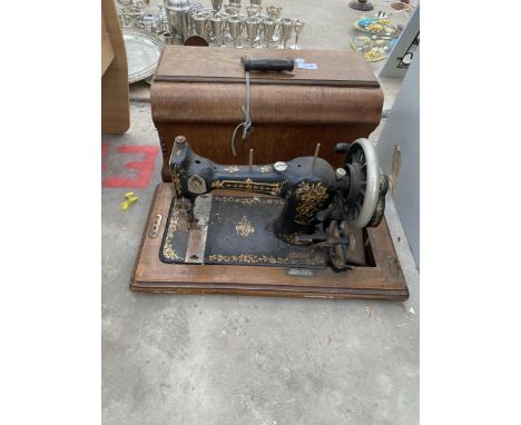 A VINTAGE SEWING MACHINE WITH WOODEN CARRY CASE