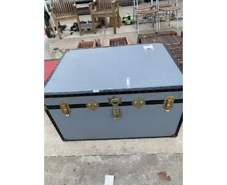 A LARGE GREY TRUNK WITH BRASS FITTINGS