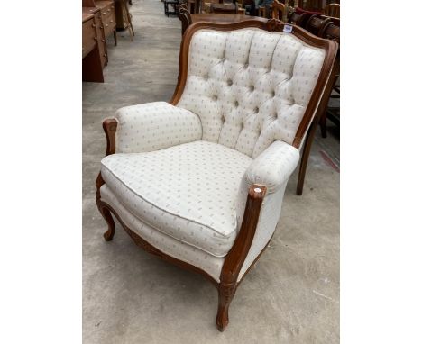 A CONTINENTAL STYLE BUTTON BACK FIRESIDE CHAIR WITH FOLIATE CARVING