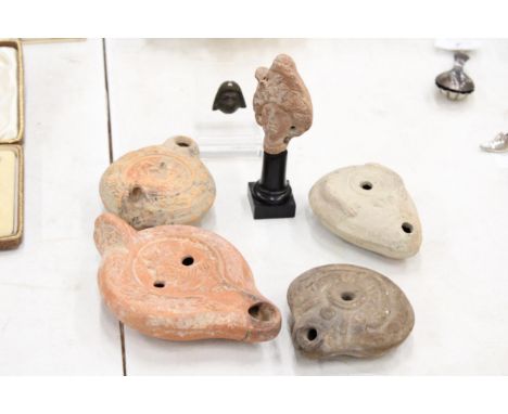 A COLLECTION OF ROMAN ANTIQUITY ITEMS TO INCLUDE FOUR OIL LAMPS, TERACOTTA BUST HEAD ON LATER STAND (12 CM) AND A SMALL BRONZ