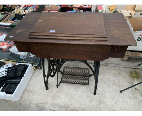 A VINTAGE JONES TREADLE SEWING MACHINE WITH CAST IRON BASE AND CABINETY