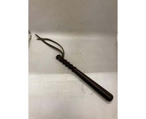 A VINTAGE DARK WOOD TRUNCHEON WITH A LEATHER STRAP
