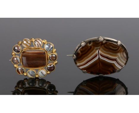 Two banded agate brooches, the first with an oval banded agate panel, 52mm diameter, the second with a central banded agate p