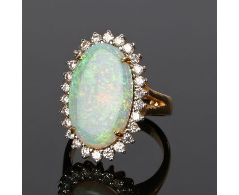 18 carat gold opal and diamond set ring, the oval opal with a round cut diamond surround, ring size O