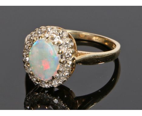 9 carat gold opal and diamond set ring, the oval opal with a diamond surround, ring size K