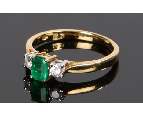 18 carat gold emerald and diamond set ring, the central emerald flanked by a diamond to either shoulder, ring size K