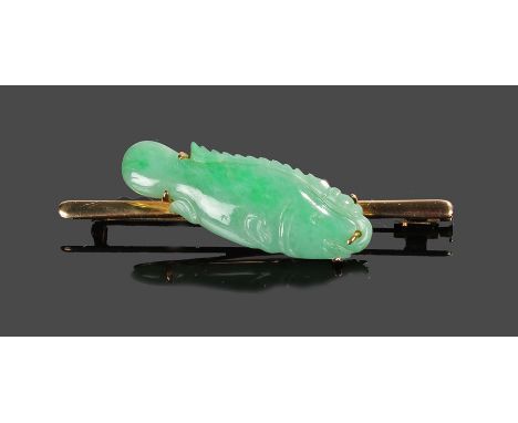 14 carat gold and jade brooch, the green jade brooch carved as a fish set to a gold bar, 60mm diameter