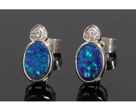 Pair of 18 carat white gold and opal set earrings, with an oval opal to each earring