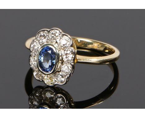 18 carat gold sapphire and diamond set ring, the central oval sapphire with a diamond surround, ring size P