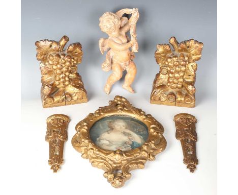 A 20th century carved lime model of a cherub, length 28cm, together with two Italian carved wooden brackets, a gilt compositi