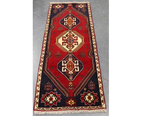 A Ghashghai runner, South-west Persia, late 20th century, the claret field with three linked medallions, within an ivory bord