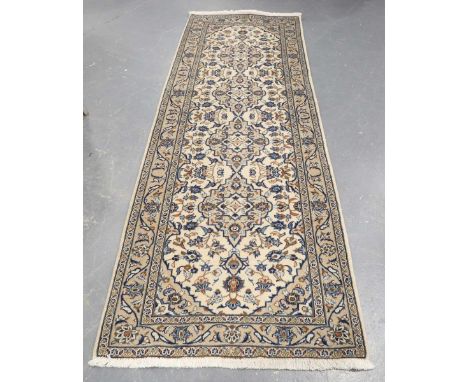 A Kashan runner, Central Persia, late 20th century, the ivory field with a column of medallions, within a scrolling vine and 