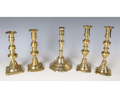An early 18th century brass candlestick with stepped octagonal base, height 21cm, together with four Victorian brass candlest