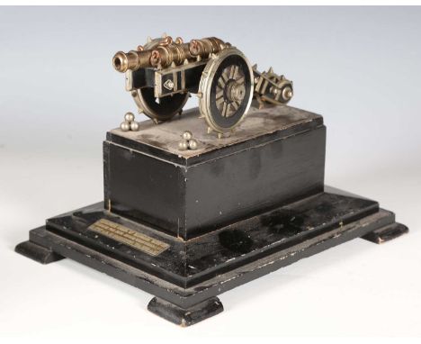 An early 20th century ebonized wood and cast metal model of a cannon, the base bearing label detailed 'Miniature Model of Zam
