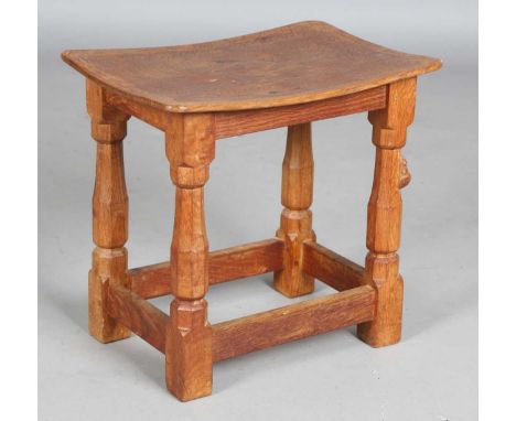 A Robert 'Mouseman' Thompson workshop oak stool, the adzed concave seat above octagonal baluster legs, one carved with mouse 