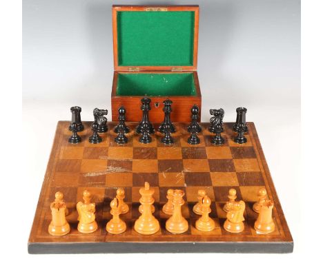 A 20th century boxwood and ebony Staunton chess set with weighted bases, height of king 9cm, together with an inlaid chessboa