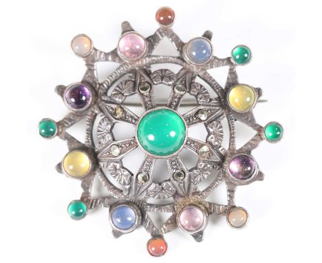 An early 20th century Arts and Crafts silver and varicoloured gemstone set brooch by Sybil Dunlop, the central circular boss 