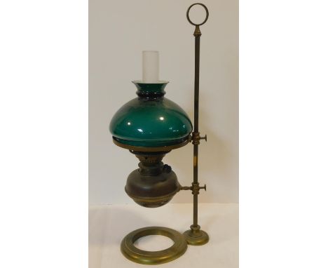 A brass Victorian student/desk oil lamp with emerald green glass shade and mounted on a brass stand with carrying handle and 