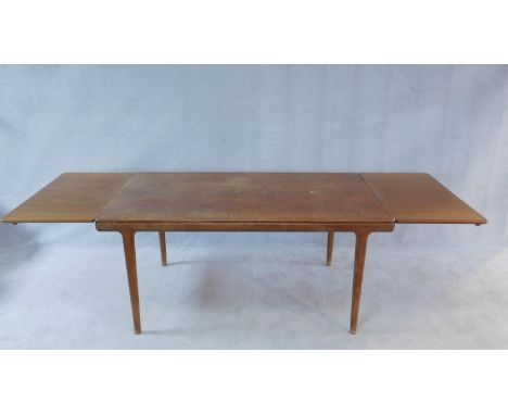 A vintage Danish style teak dining table with extending swivel action leaves. H.74 W.160 D.88cm 